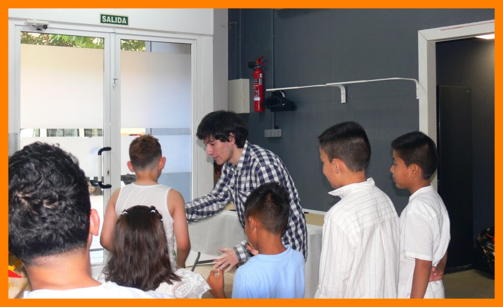Mago Ru rodeado de niños atentos durante su espectáculo de magia infantil